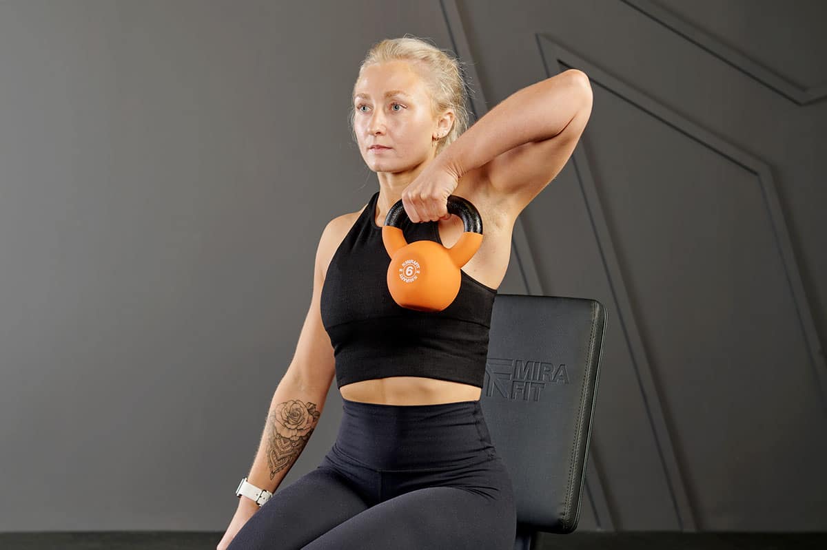 a woman doing Single arm kettlebell Tricep Extension 